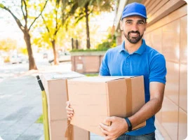 Mann mit Paket im Außendienst, freundlicher Zusteller liefert Pakete vor einem Gebäude, optimal für Verpackungs- und Versanddienstleistungen.