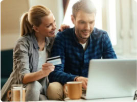 Junge Frau erklärt einem Mann mit Kreditkarte die Vorteile beim Online-Shopping.